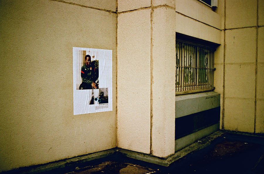 un portrait de l’exposition collé sur un mur du passage