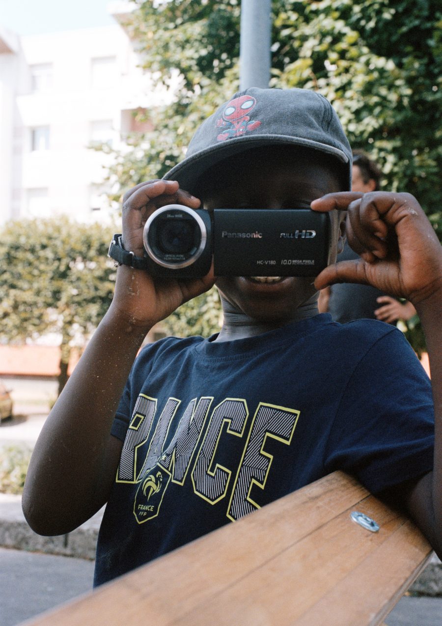 un enfant filme avec un caméscope, sur la dalle