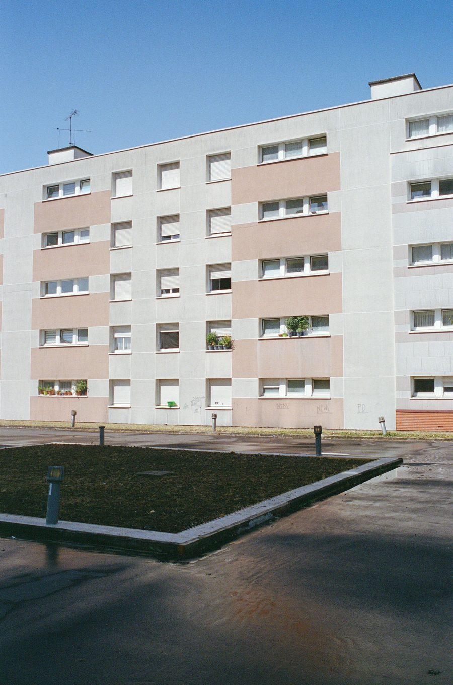 la dalle des Trois Tours, un immeuble rose et blanc au fond