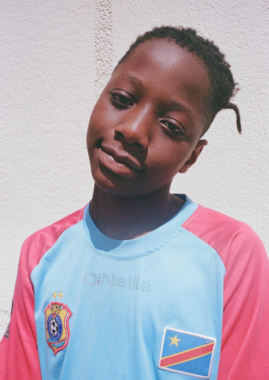 un garçon en maillot de football bleu et rose, portrait