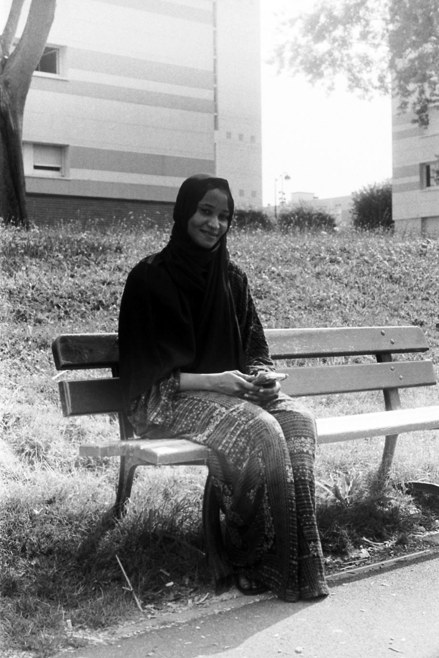 une femme assise sur un banc, portrait en noir et blanc