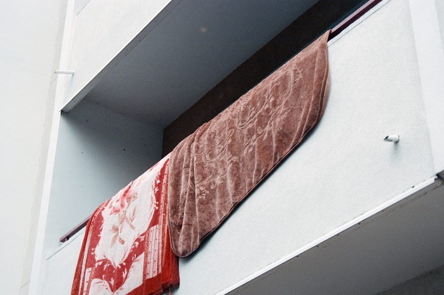 un tapis rouge qui sèche sur une rambarde de balcon